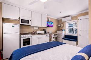 a kitchen with white cabinets and a blue bed at Waterfront Studio - Bay Views, Steps to Comm St in Provincetown +19 photos