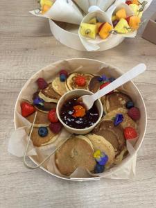 a plate of cookies with fruit and a bowl of sauce at Bonnye's guest house in Ramsgate +16 photos