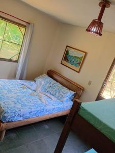 a small bedroom with a bed with blue sheets at Pousada Quintal da Cachoeira in São Thomé das Letras +19 photos