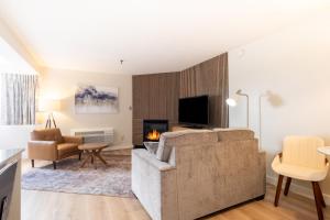 a living room with a couch and a fireplace at Fireside Inn & Suites Waterville in Waterville