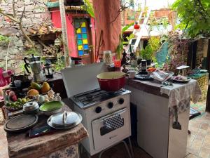 an outdoor kitchen with a stove and a pot on it at CASA DE RETALHOS Boutique Albergue, casaril histórico, com 5 suítes individuais e cozinha coletiva, no coração da vila de Igatu-Ba, que preserva fortes traços culturais da época do garimpo, venha viver uma experiência única! in Igatu