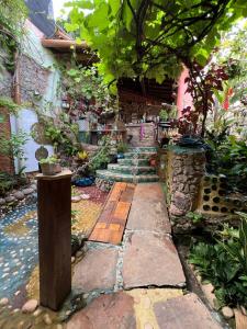 a garden with a stone path and a house at CASA DE RETALHOS Boutique Albergue, casaril histórico, com 5 suítes individuais e cozinha coletiva, no coração da vila de Igatu-Ba, que preserva fortes traços culturais da época do garimpo, venha viver uma experiência única! in Igatu