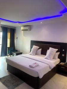 a bedroom with a large bed with a blue ceiling at Mambillah Hotel Ikorodu in Ikorodu +33 photos