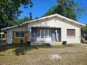 a small white house with a large window at Ici et nulle part ailleurs in Saint-Vivien-de-Médoc
