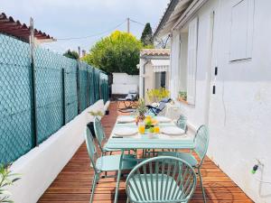 a patio with a table and chairs on a balcony at Jolie maison de vacances proche du centre et de la mer in Saint-Raphaël