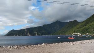 a body of water with mountains in the background at sunset lovers cottage in Canefield
