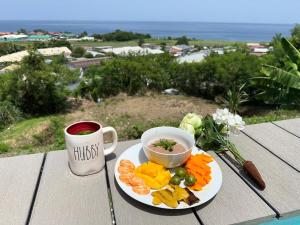 a plate of fruit and a cup of coffee on a table at sunset lovers cottage in Canefield