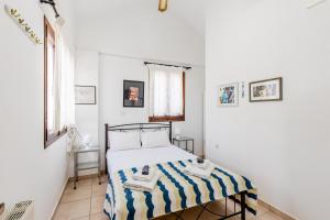 a bedroom with a bed with a striped blanket at Demie's Maisonette in Plytra with SeaView in Plytra