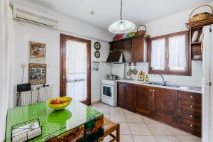 a kitchen with wooden cabinets and a green counter top at Demie's Maisonette in Plytra with SeaView in Plytra +7 photos