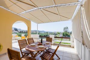 a dining room with a table and chairs on a balcony at Demie's Maisonette in Plytra with SeaView in Plytra