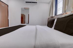 a large white bed in a room with a window at Hotel O Shree Lodging in Aurangabad
