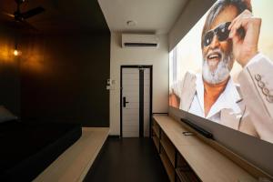 a room with a tv with a man in sunglasses on the screen at Urban Space in Khammam