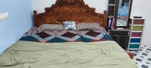 a large bed with a wooden headboard in a bedroom at Urban Space in Khammam