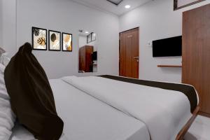 a bedroom with a bed and a flat screen tv at Hotel O Shree Lodging in Aurangabad
