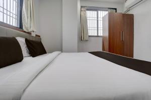 a large white bed in a small room with windows at Hotel O Shree Lodging in Aurangabad +32 photos