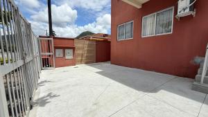 an empty courtyard of a red building with a fence at Ap 2 Quartos em Caiobá, garagem, Wi-Fi in Matinhos