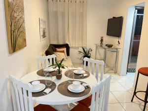 a dining room with a white table and chairs at Ap 2 Quartos em Caiobá, garagem, Wi-Fi in Matinhos