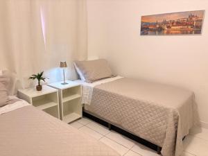 a bedroom with two beds and a lamp on a table at Ap 2 Quartos em Caiobá, garagem, Wi-Fi in Matinhos