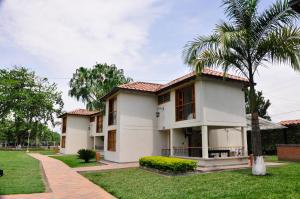 a house with a palm tree in front of it at Villa Beatriz in Palestina