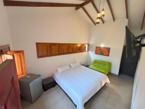 a bedroom with a bed and a green chair at Villa Beatriz in Palestina +11 photos