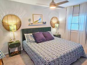 a bedroom with a bed with purple pillows and two lamps at Heavenly Hideaway in Daytona Beach
