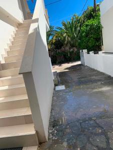 a stairway leading up to a white wall at Miminllari APARTMENTS 2 in Pefkochori +6 photos