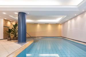 a swimming pool in a hotel with a blue pole at JOHAN - Rooms & Breakfast Merano in Marlengo