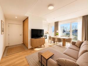 a living room with a couch and a tv and a table at Sadama Apartment in Haapsalu