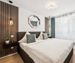 a bedroom with a large bed with a mirror on the wall at Prime Host Dream Apartment in Karlsruhe