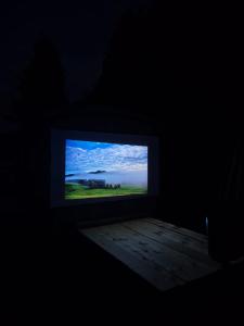 a television screen in a dark room with a view of the ocean at Sommerkino in Krispl