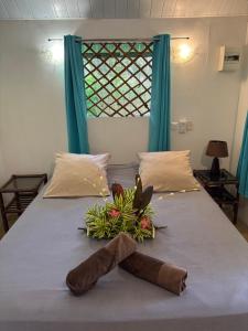 a flower arrangement on a bed with a towel on it at Poe Guesthouse in Avatoru