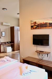 a hotel room with two beds and a flat screen tv at Livora Boutique in Budapest