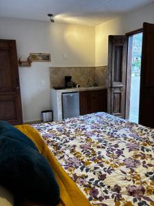 a bedroom with a bed with a flowered blanket on it at Casa Luminara in Guanajuato