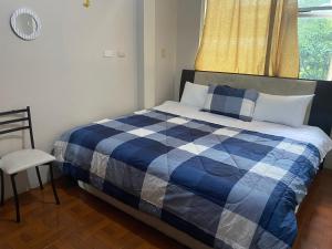a bedroom with a blue and white bed and a chair at El refugio de Lolita, tu hogar en Loja in Loja