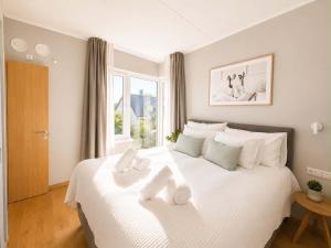a bedroom with a white bed with towels on it at Sadama Apartment in Haapsalu
