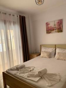 a bedroom with a bed with a bow on it at Miminllari APARTMENTS 2 in Pefkochori