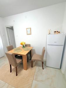 a dining room with a table and a refrigerator at Lucky apartman in Šabac