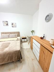 a bedroom with a bed and a wooden desk at Lucky apartman in Šabac