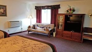 a hotel room with a bed a chair and a television at Keystone Boardwalk Inn and Suites in Keystone