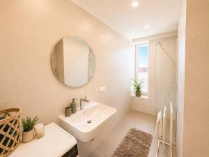 a white bathroom with a sink and a mirror at Sadama Apartment in Haapsalu +5 photos