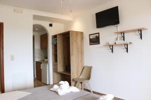 a bedroom with a bed and a tv on the wall at Panorama Studios in Kefalos