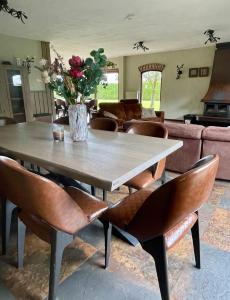 a table and chairs with a vase of flowers on it at 'Onze Knoerishoeve' in Odiliapeel +18 photos