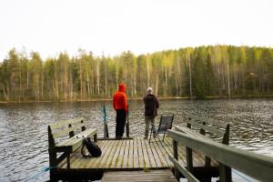 two people standing on a dock near a lake at Kyyronkaita in Mikkeli