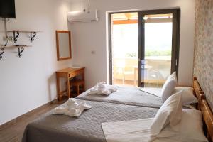 a hotel room with two beds and a window at Panorama Studios in Kefalos