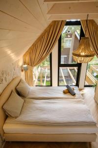a bed in a room with a large window at ORO Baltic in Pobierowo
