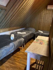 a room with three beds and a table at 'Onze Knoerishoeve' in Odiliapeel