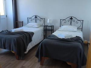 two beds sitting next to each other in a room at Casa do Marcelino Lagarto in São Roque do Pico