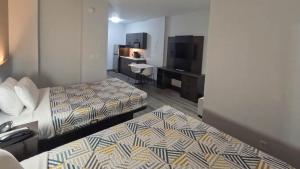 a hotel room with two beds and a desk at Studio 6-Brownsville, TX in Brownsville +49 photos
