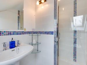 a white bathroom with a sink and a shower at 3 Bed in Swansea oc-bn172 in Ystalyfera +27 photos