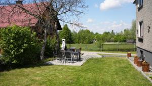 a patio with a table and chairs in a yard at Pokoje Green House in Ustroń